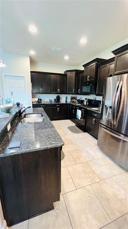 1597 West Caroline Path Lecanto, FL 34461 - Photo 8 of 28 a kitchen with stainless steel appliances granite countertop a sink a stove a microwave a counter top space and cabinets