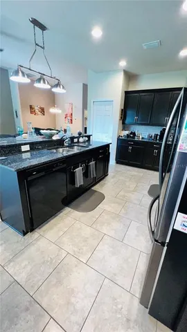 a kitchen with stainless steel appliances granite countertop a stove a sink and a refrigerator