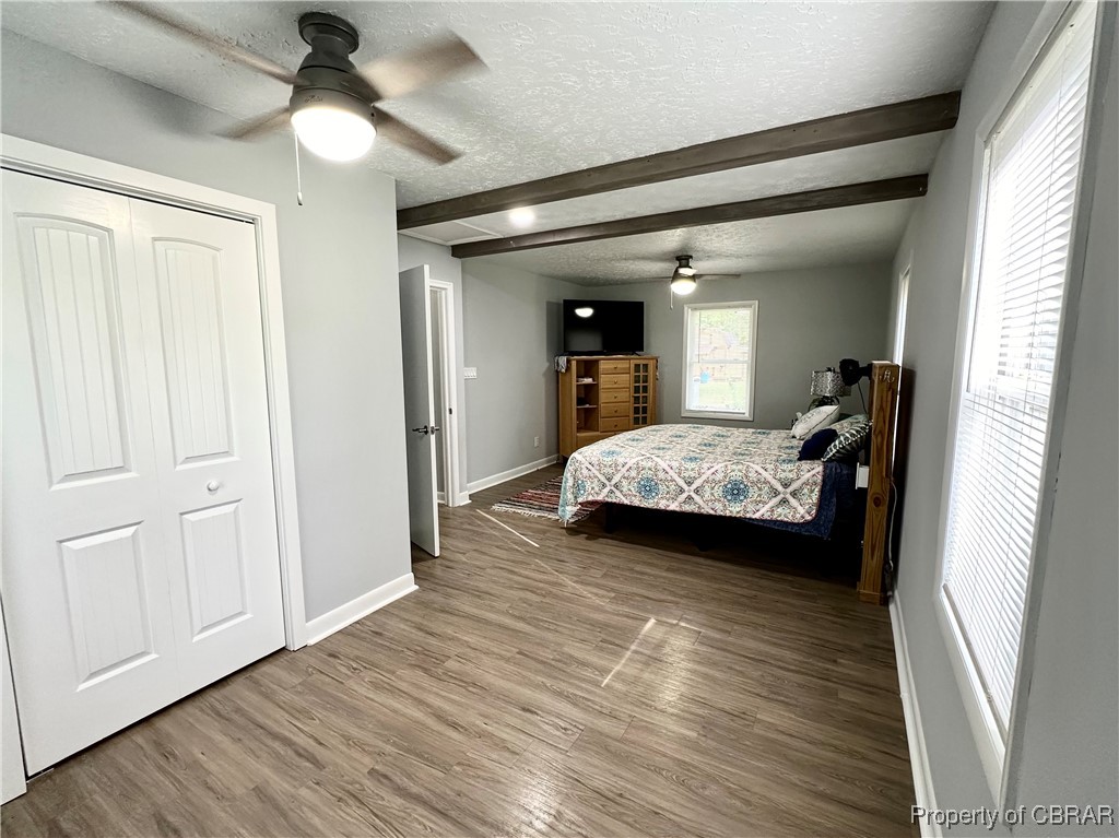 7809 Ark Road Gloucester, VA 23061 - Photo 16 of 32 Bedroom with hardwood / wood-style floors, ceiling fan, beam ceiling, and a closet