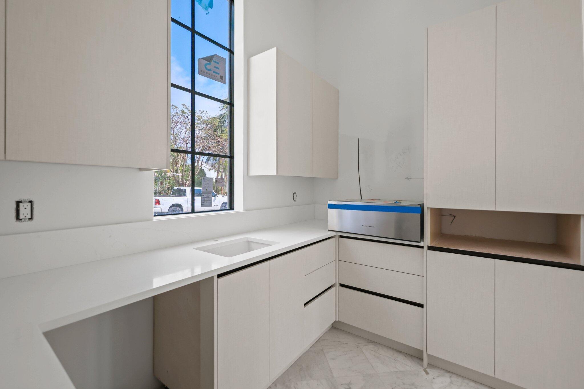 298 Northeast 8th Street Boca Raton, FL 33432 - Photo 11 of 48 a kitchen with white cabinets and a sink