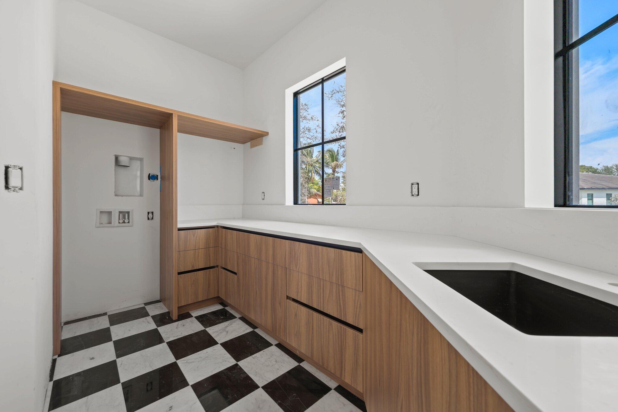 298 Northeast 8th Street Boca Raton, FL 33432 - Photo 19 of 48 a kitchen with a checkered floor and white cabinets