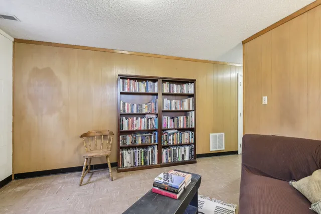 a living room with furniture and a bookshelf