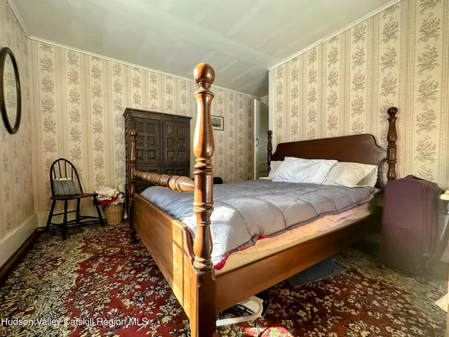 a bedroom with a bed chair and a window