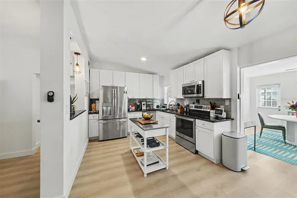a kitchen with white cabinets and stainless steel appliances