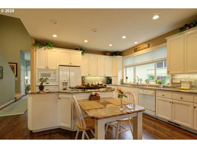 a kitchen with stainless steel appliances granite countertop a sink a stove top oven a counter space and cabinets