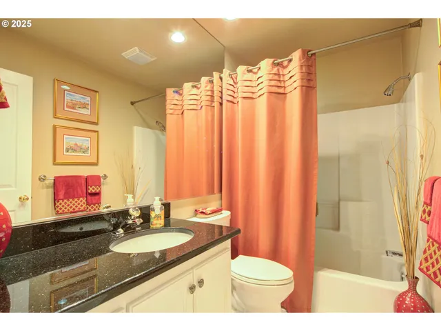 a bathroom with a sink a toilet and a shower curtain