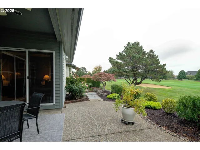 a backyard of a house with a table and chairs