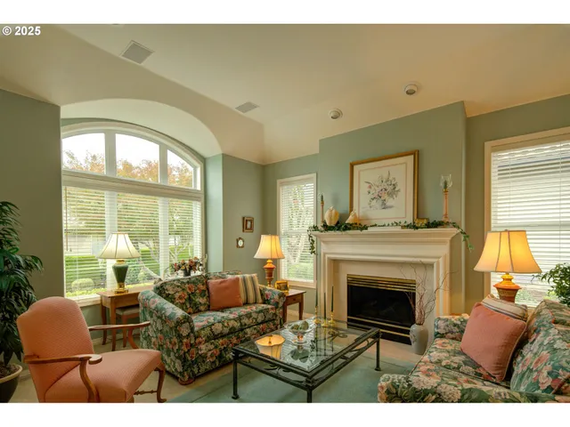 a living room with furniture a large window and a fireplace