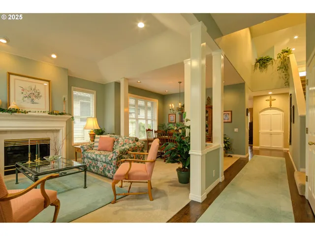 a living room with furniture a fireplace and a chandelier