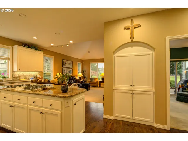 a kitchen with stainless steel appliances granite countertop a sink cabinets and wooden floor