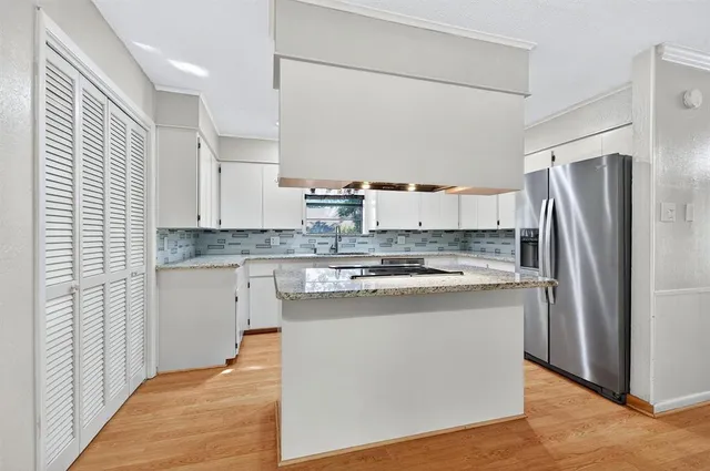 a kitchen with stainless steel appliances granite countertop a refrigerator and a stove