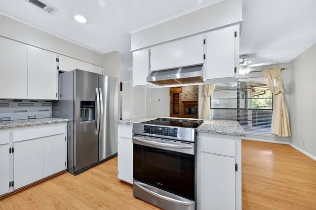 a kitchen with granite countertop a stove and stainless steel appliances