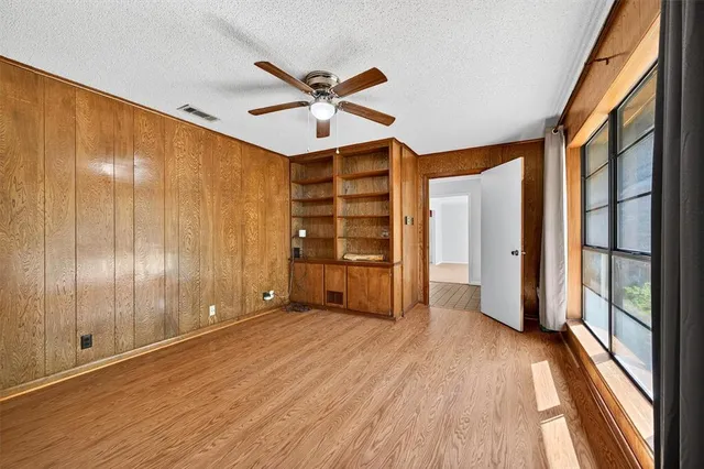 a view of a big room with wooden floor and windows
