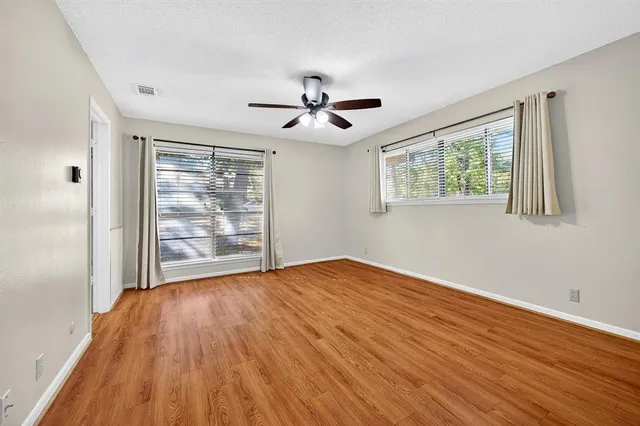 a view of an empty room with wooden floor