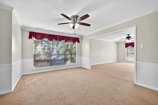 a view of empty room with window and ceiling fan