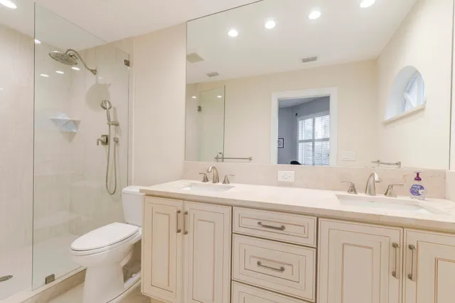 a bathroom with a sink a toilet a mirror and shower