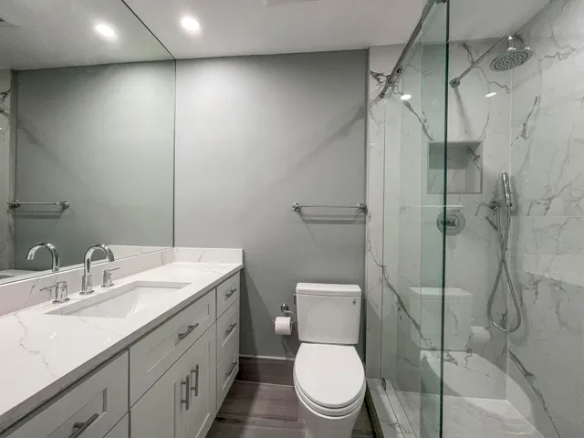 a bathroom with a toilet sink vanity and mirror