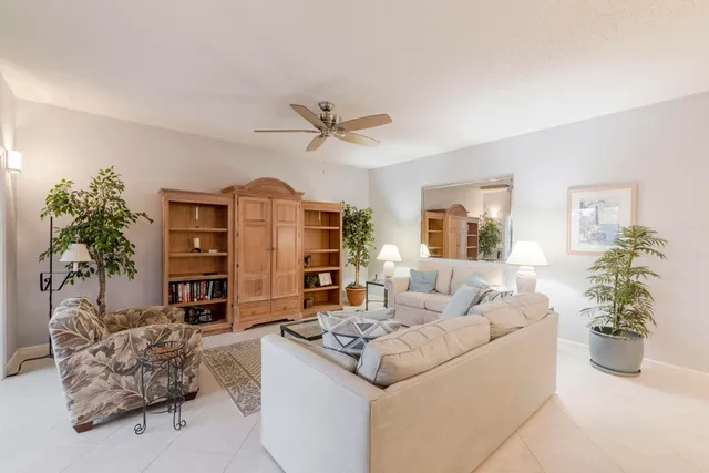 a living room with furniture a chandelier and a large window