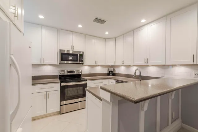 a kitchen with stainless steel appliances granite countertop a sink stove and microwave