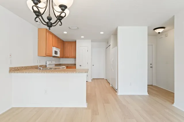 a kitchen with stainless steel appliances granite countertop a stove a sink dishwasher and a microwave oven with white cabinets