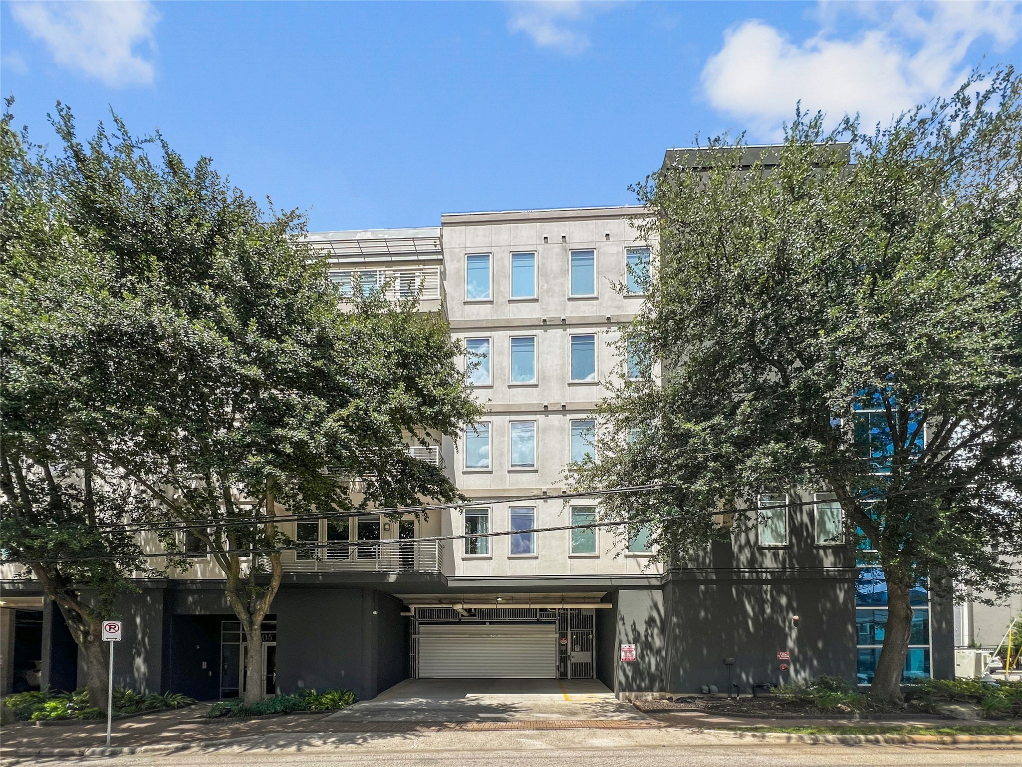 505 Jackson Hill Street, Unit 206 Houston, TX 77007 - Photo 3 of 35 a front view of a building with a garden and trees