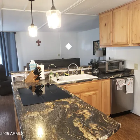 a kitchen with stainless steel appliances granite countertop a sink a stove and a wooden floors