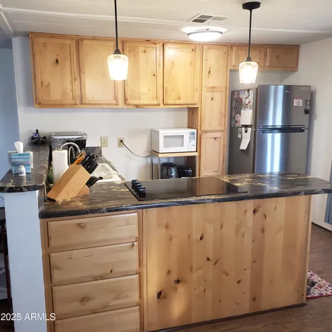 a kitchen with stainless steel appliances granite countertop a sink and a refrigerator