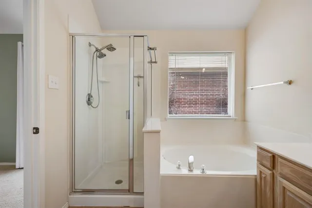 a bathroom with a bathtub a shower and a sink