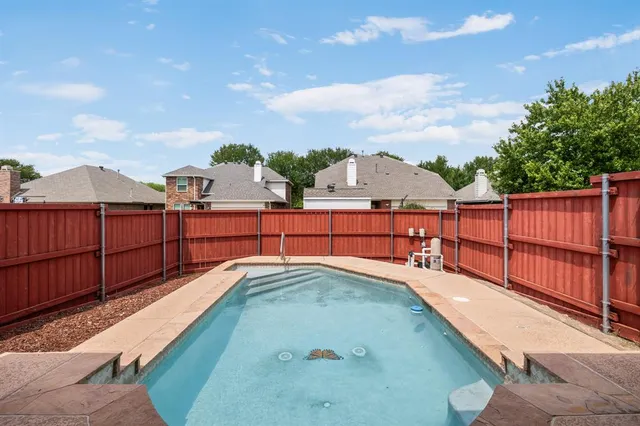 a view of a backyard with a tub and wooden fence