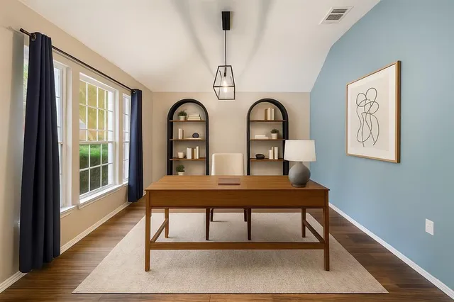 a view of a workspace with furniture and window