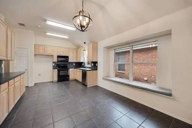 a large kitchen with stainless steel appliances kitchen island granite countertop a refrigerator and a stove top oven