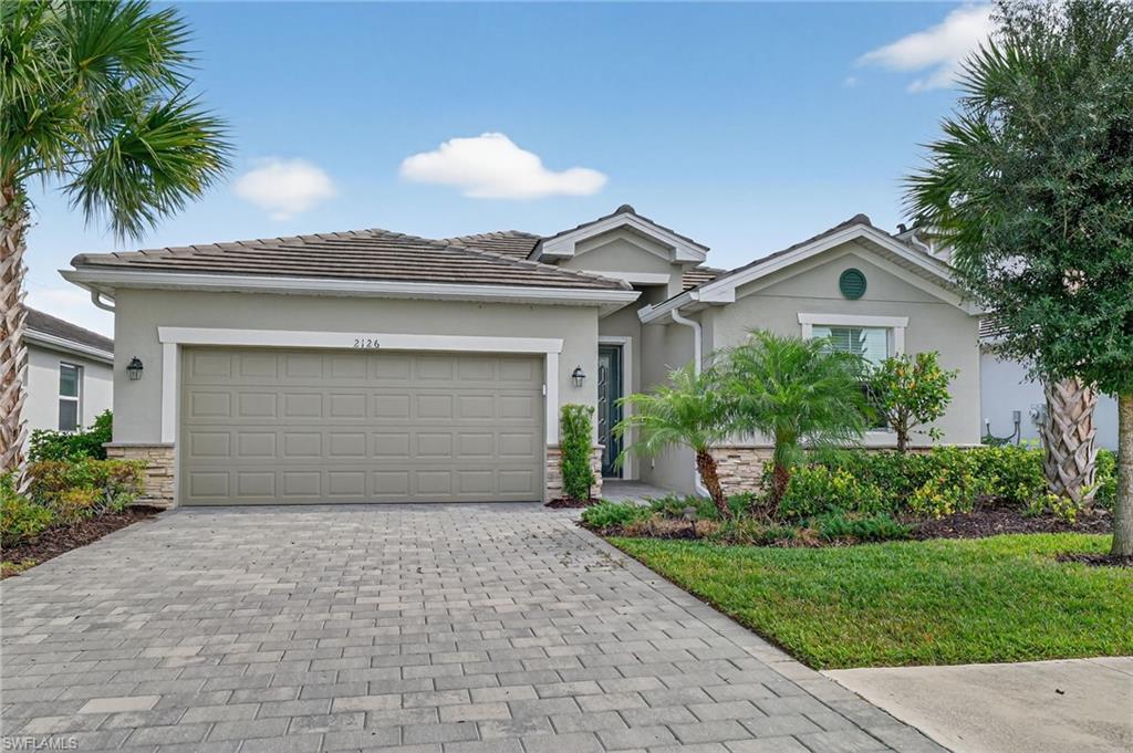 2126 Hamlin Street Naples, FL 34120 - Photo 1 of 38 a front view of a house with a garden and trees