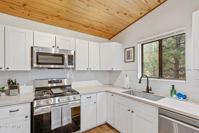 a kitchen with stainless steel appliances a stove a sink a microwave and cabinets