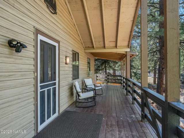 a view of a balcony with chairs and wooden floor