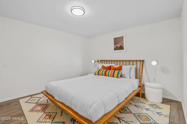 a bedroom with a bed and a lamp on the dresser