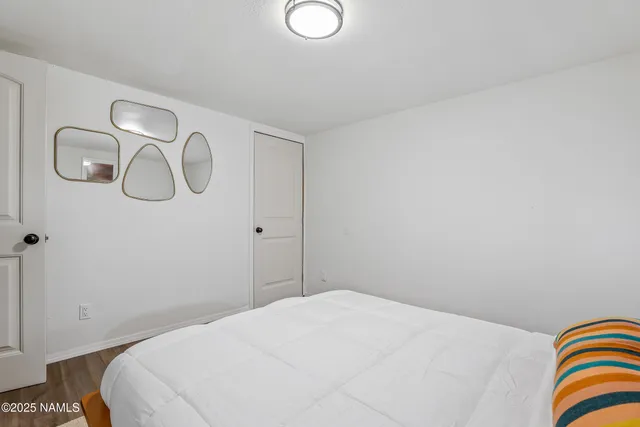 a bedroom with a bed and a lamp on the dresser