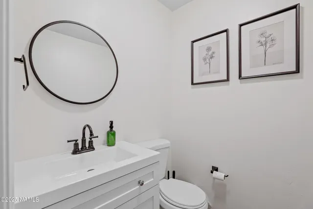 a bathroom with a sink mirror and toilet