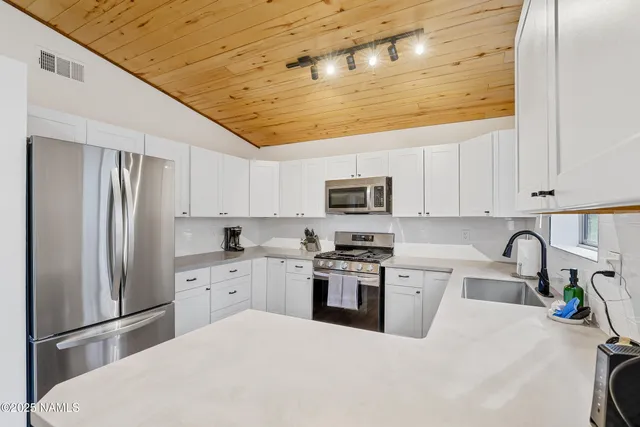 a kitchen with stainless steel appliances a refrigerator sink and cabinets