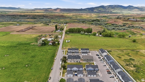 391 South 440th Street West Preston, ID 83263 - Photo 24 of 28 Aerial perspective showcasing a residential development with multiple unit types, paved parking areas, and mature trees