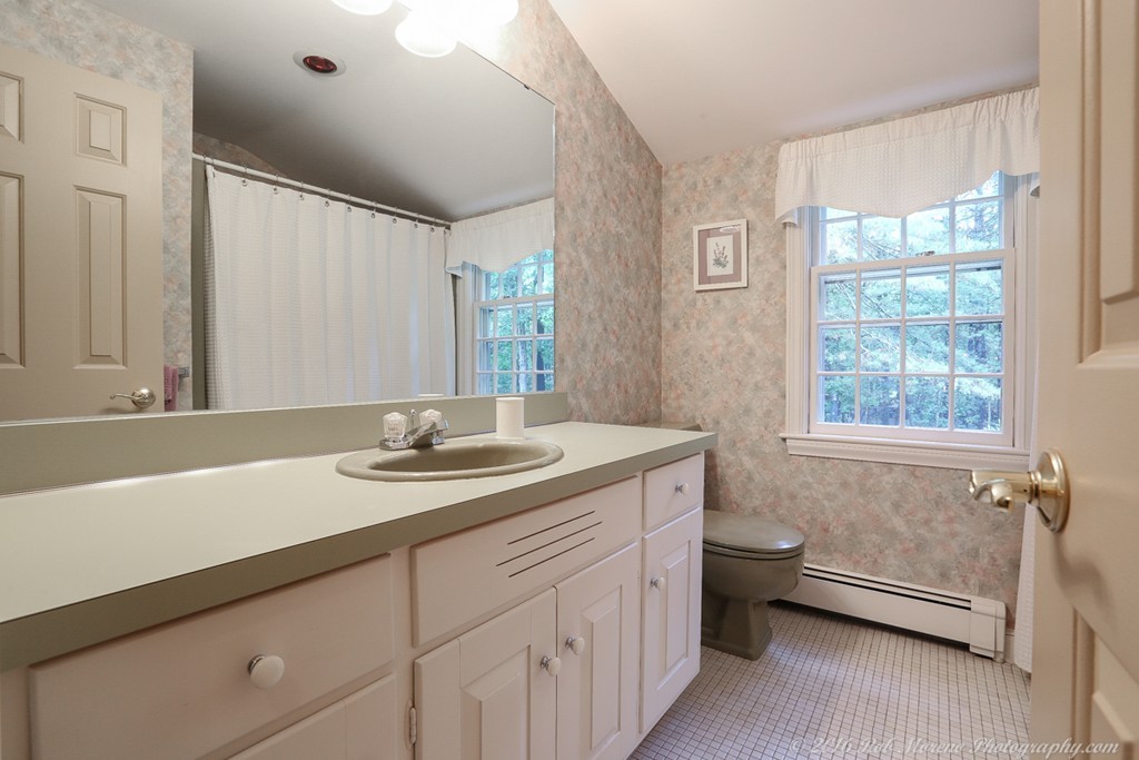 18 High Ridge Road Boxford, MA 01921 - Photo 20 of 30 a bathroom with a granite countertop sink a toilet a mirror and a tub
