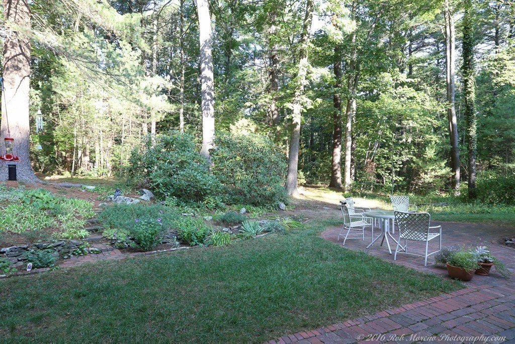 18 High Ridge Road Boxford, MA 01921 - Photo 26 of 30 a view of a yard with table and chairs and wooden fence