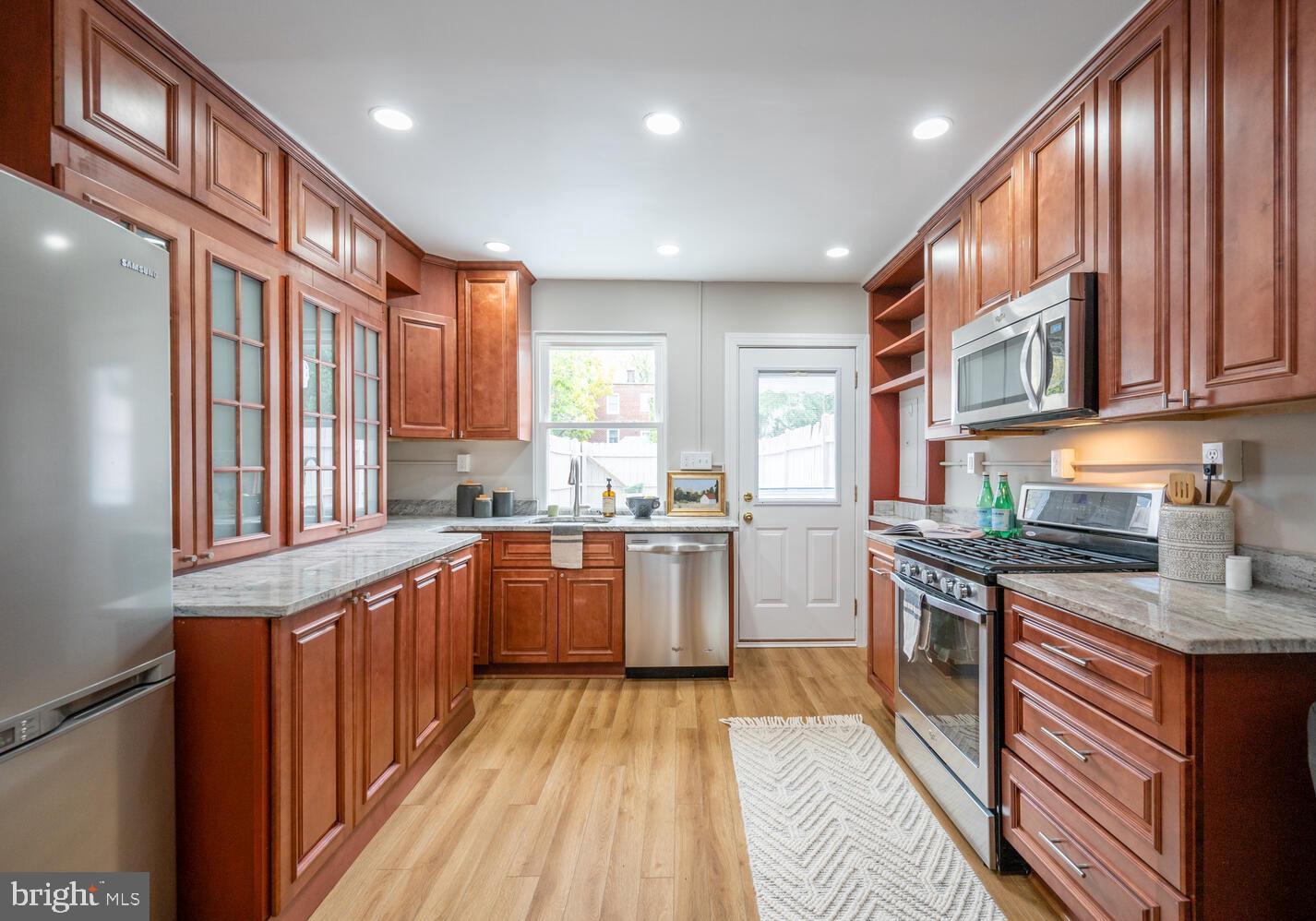 a kitchen with stainless steel appliances granite countertop lots of counter top space and a refrigerator