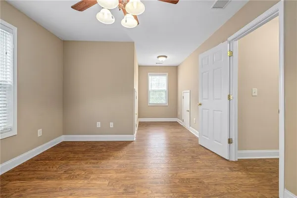 a view of an empty room with a window and wooden floor