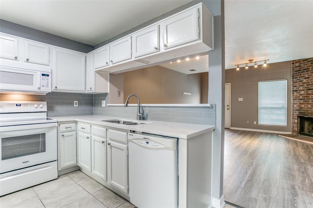 12 Abbey Road Euless, TX 76039 - Photo 5 of 12 Kitchen with white appliances, white cabinetry, backsplash, and light stone counters