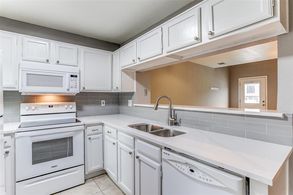 12 Abbey Road Euless, TX 76039 - Photo 6 of 12 Kitchen featuring white appliances, white cabinets, decorative backsplash, light tile patterned flooring, and light stone countertops