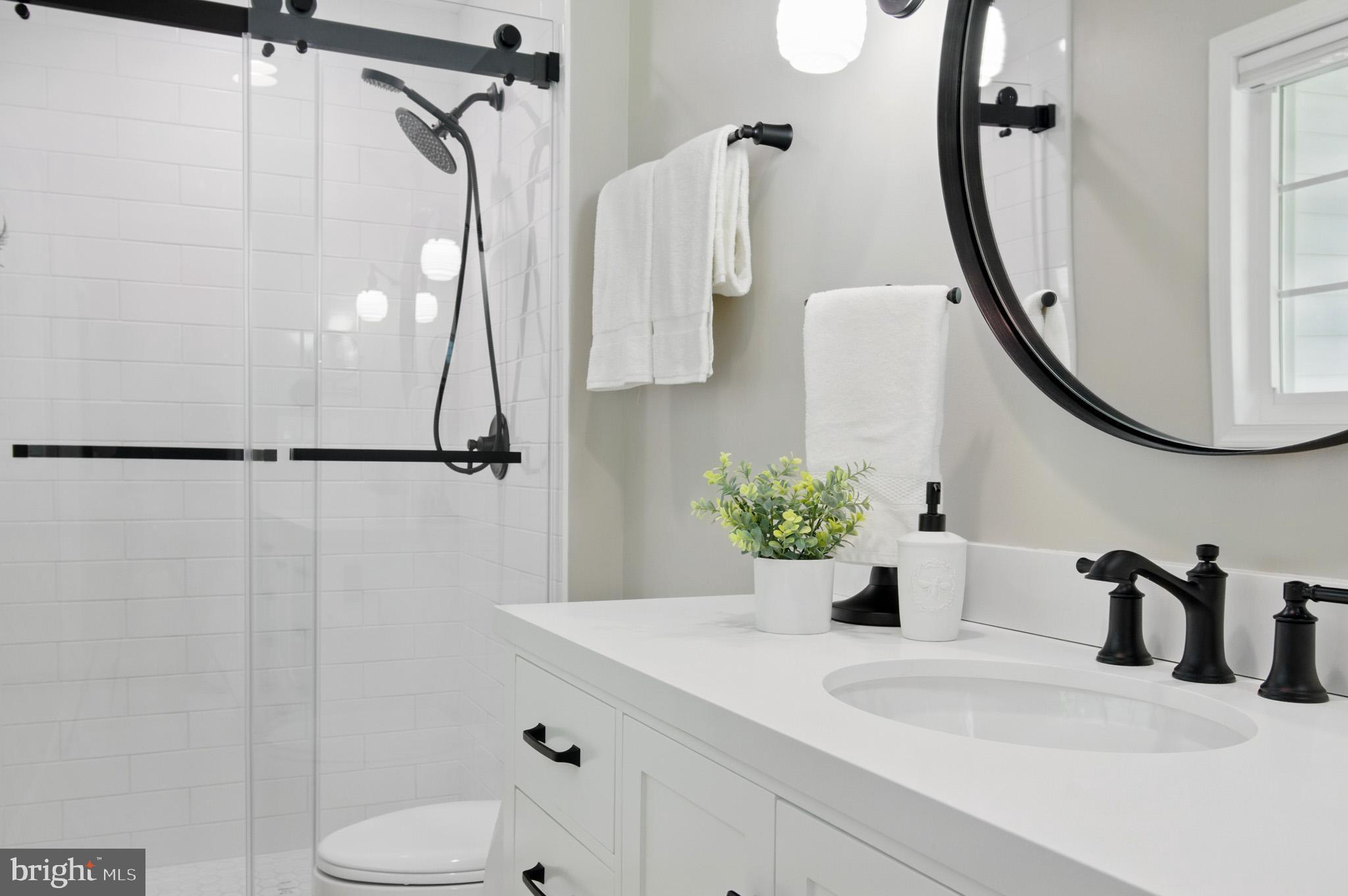 3633 Valley Road Ellicott City, MD 21042 - Photo 37 of 72 a bathroom with a granite countertop sink a toilet and shower curtain