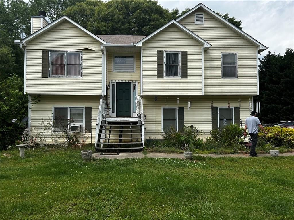 a front view of a house with a yard and garden