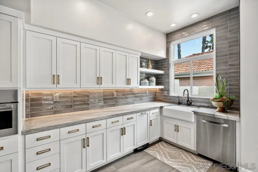 12 Mardi Gras Road Coronado, CA 92118 - Photo 7 of 70 a kitchen with granite countertop a sink stainless steel appliances white cabinets and a window
