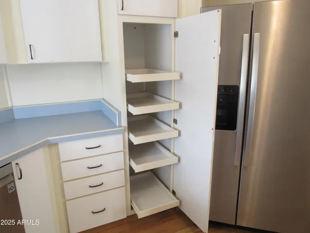 a view of walk in closet with empty racks