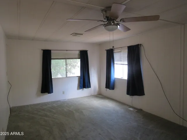 a view of a livingroom with a ceiling fan and window